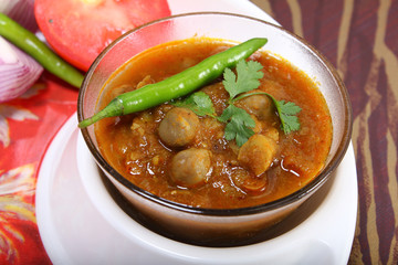 indian spicy chana masala with raw chickpeas and green chilli to