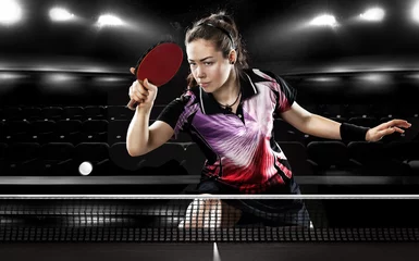Tuinposter Young pretty sporty girl playing table tennis on black © Mike Orlov