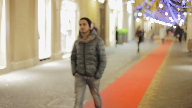 Man walking outdoors at night and smiles on the camera