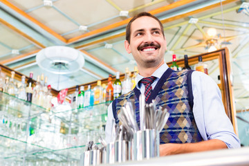 Barista im Cafe bietet Latte Macchiato im Glas an