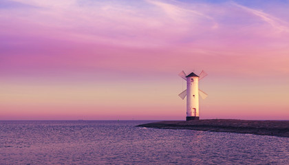 Purple sunrise over Baltic Sea, Stawa Mlyny windmill beacon in Swinoujscie, Poland.