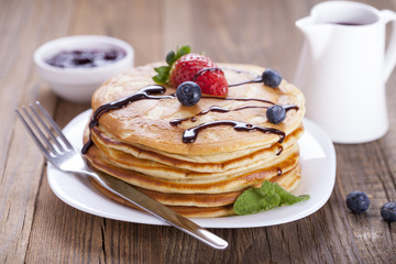 Delicious sweet American pancakes on a plate with fresh fruits