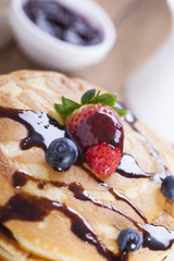 Delicious sweet American pancakes on a plate with fresh fruits