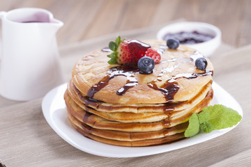 Delicious sweet American pancakes on a plate with fresh fruits