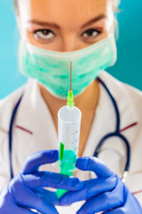doctor in mask holding syringe with injection