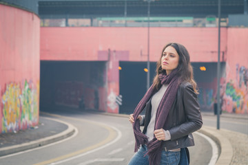 Fototapeta premium Beautiful young brunette posing in the city streets