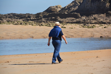 jubilado caminando por la playa