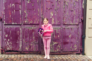 Little girl in a city, wearing bright pink clothes