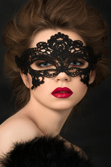Portrait of young adorable woman in black party mask