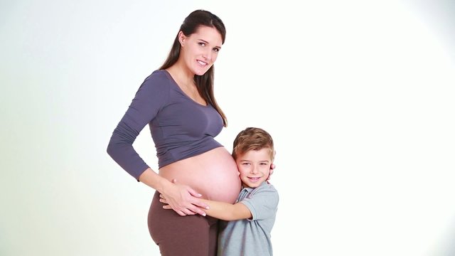 little boy kisses her mother paunch