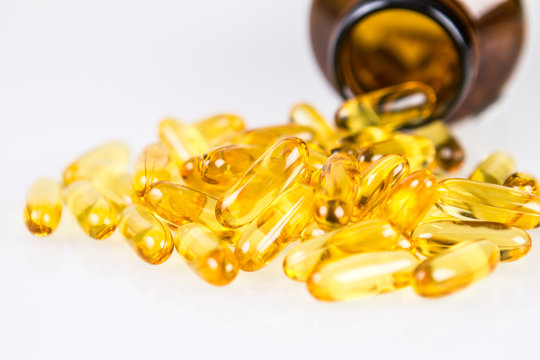 Closeup yellow soft gelatin supplement fish oil capsule