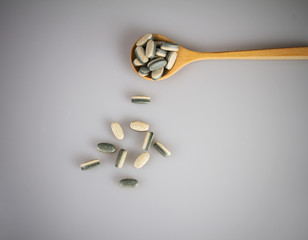 Herbal Supplement vitamin pills or tablets in wooden spoon