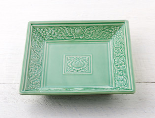 Empty green ceramic plate on wooden table