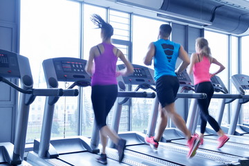 Obraz premium Group of people running on treadmills