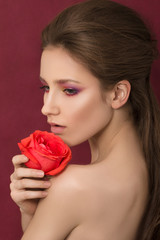 Beauty portrait of young brunette woman holding red rose