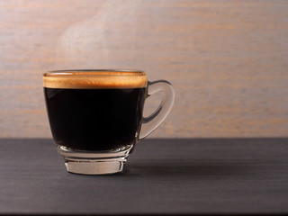 Cup of hot espresso coffee on wood board