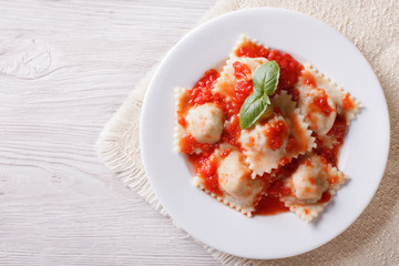 Ravioli with tomato sauce on a plate. horizontal top view