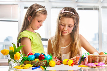 Obraz na płótnie Canvas Children paint Easter eggs at home.