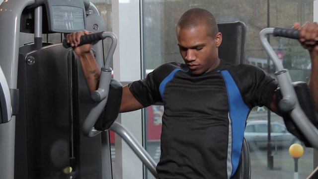 Male working out in gym on exercise machine