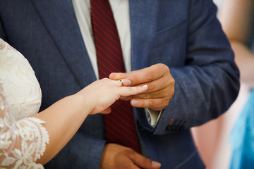 bride and groom are changing rings on wedding