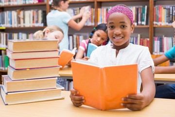Cute pupils reading in library