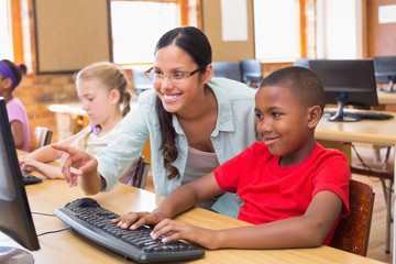 Cute pupils in computer class with teacher