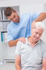 Obraz premium Therapist giving massage to senior male patient