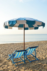 beach canvas beds with blue and white umbrella