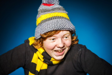 Expressive teenage boy dressed in colorful hat close-up portrait