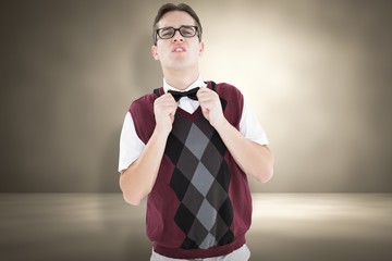 Composite image of geeky hipster fixing his bow tie