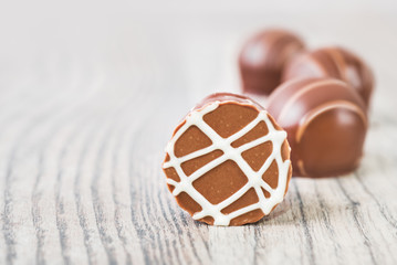 Chocolate truffles on a wooden surface, text space