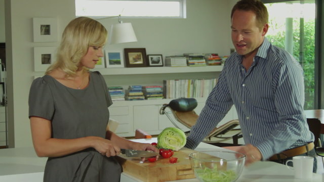 Wide shot off couple in ktichen preparing a healthy salad