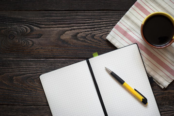Notebook, pen and coffee pot on the table