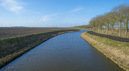 Canal along a plowed field in winter