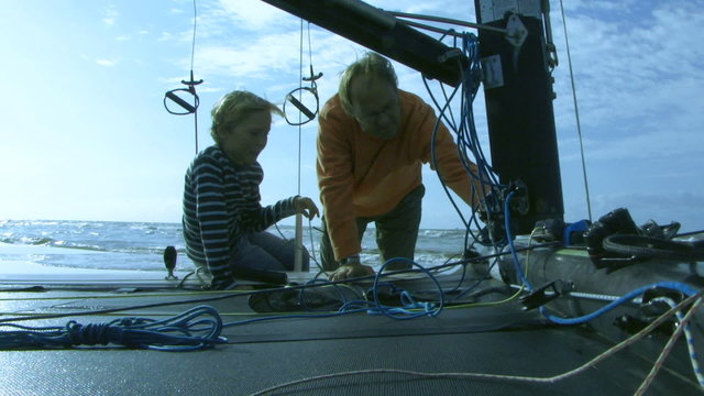 MS, Father giving son instructions on sailboat