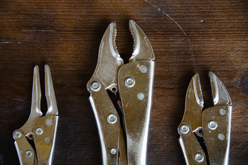 close up locking pliers on wooden background