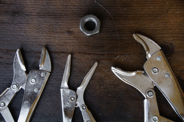 close up locking pliers on wooden background
