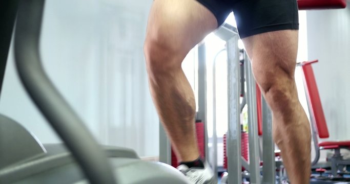 Strong male sports leg on a simulator orbitrek