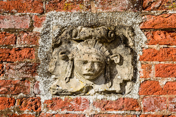 Decorative stone face on a brick wall