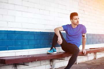 young male athlete sitting on the bench (intentional sun glare)