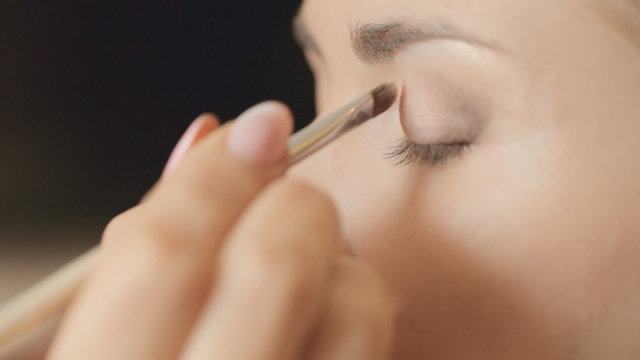 Visagist puts shadow on the eyelid, close-up