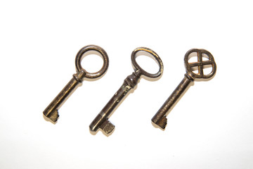 Three old keys on a white background