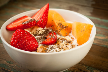 Healthy breakfast of muesli, strawberries, melon and yoghurt.