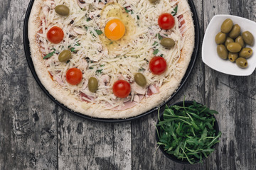 Italian pizza with egg in a center ready to bake