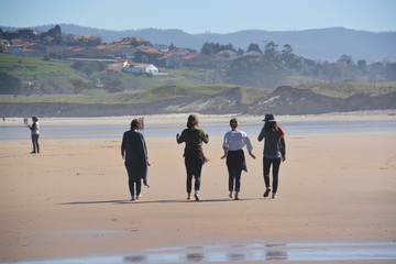 grupo de chicas paseando por la playa de oyambre