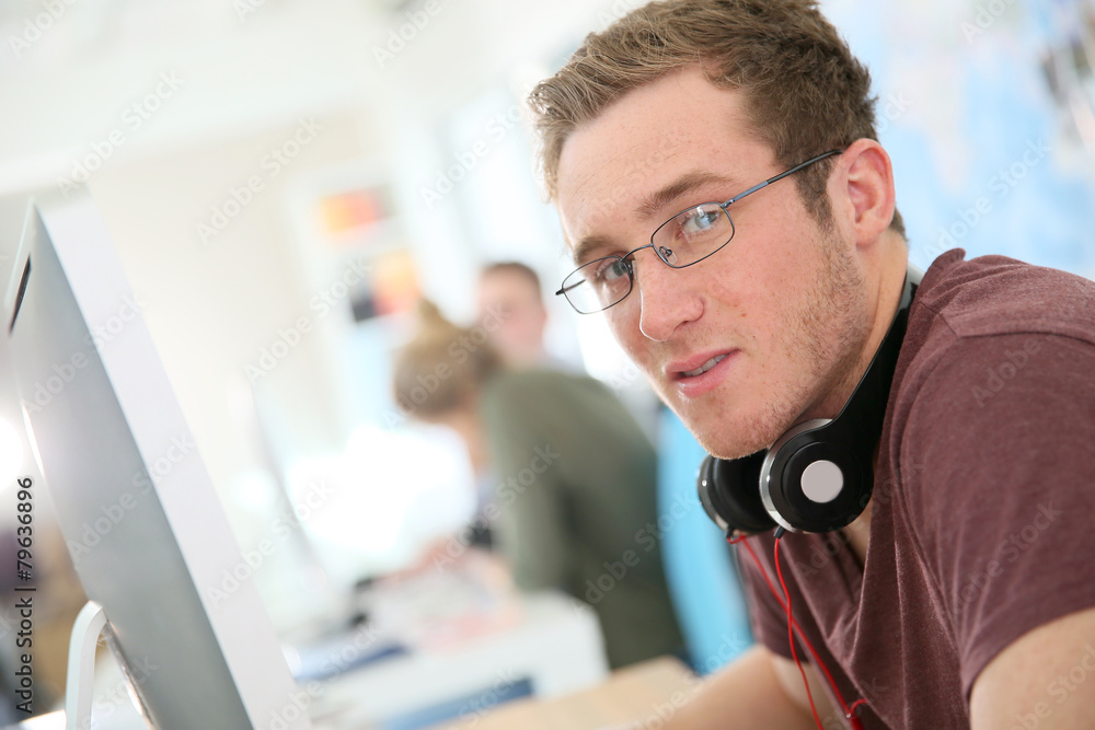 Aufkleber student with eyeglasses sitting in front of desktop