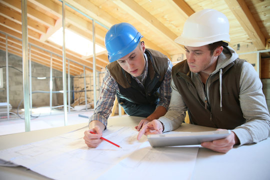 Young men in professional training working on building site