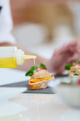 Closeup of olive oil being poured over appetizer
