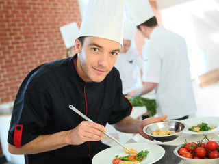 Chef in restaurant kitchen preparing dish