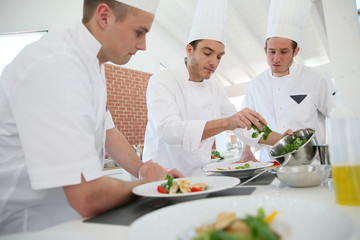 Chef training students in restaurant kitchen